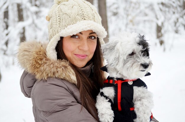 Adolescent appréciant avec son chien une journée dans la neige