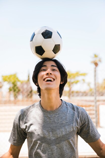 Adolescent asiatique, tenue, balle football, sur, tête