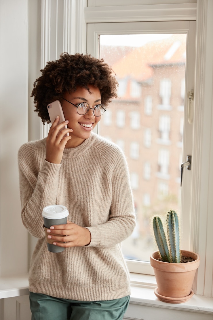 Photo gratuit adolescent assez heureux avec son téléphone posant à la maison