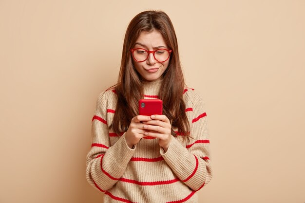 Adolescent au gingembre portant des lunettes rouges
