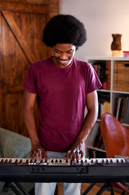 Photo gratuite adolescent à coup moyen avec piano à la maison