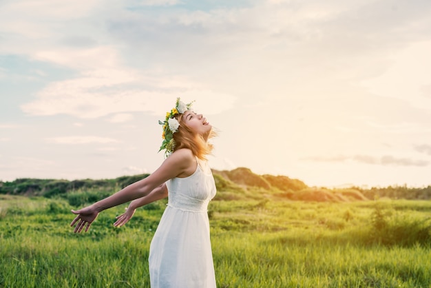 Adolescent avec couronne en profitant dans la prairie