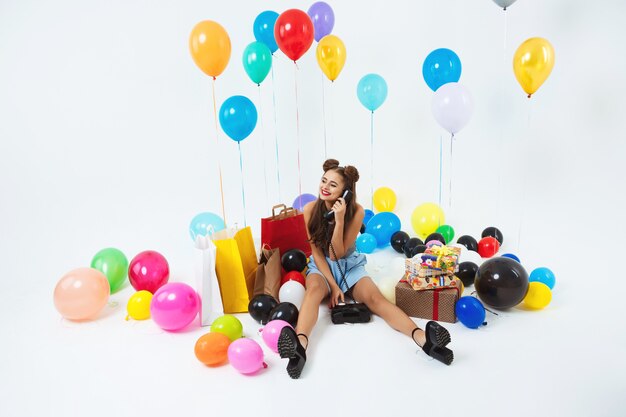 Adolescent heureux ayant une grande fête d'anniversaire recevant des appels téléphoniques de la famille