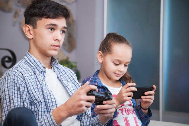 Adolescent, jouer à des jeux vidéo près de soeur