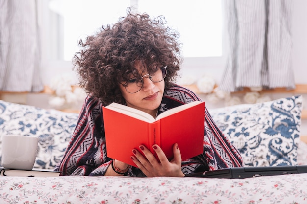 Photo gratuite adolescent, livre de lecture sur le lit