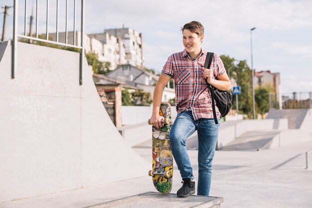Adolescent avec skateboard à la frontière