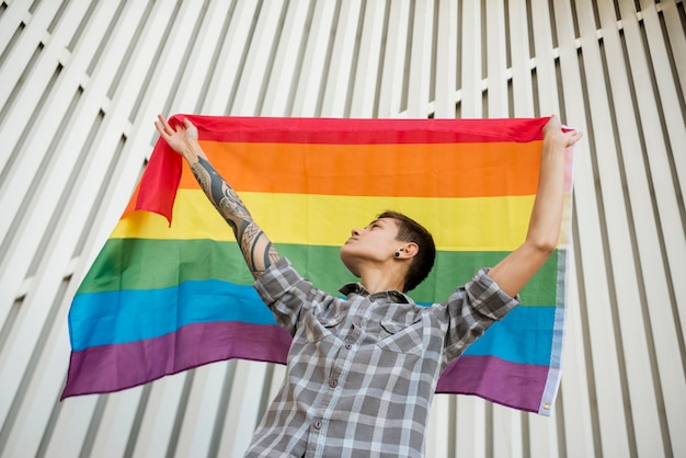 Adolescent tenant un drapeau arc-en-ciel