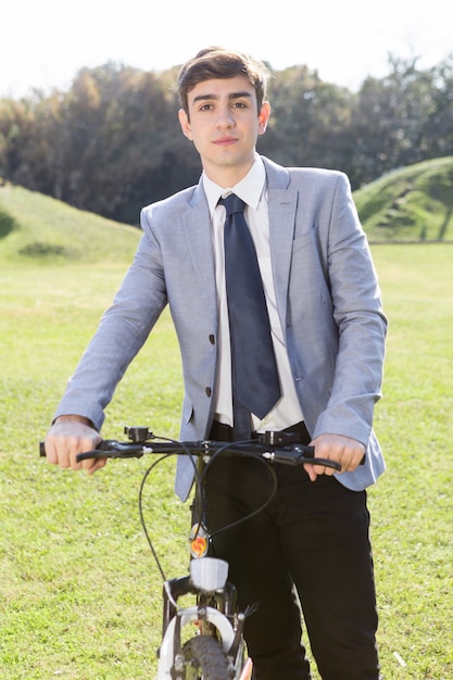 Adolescent tenant son vélo dans le jardin