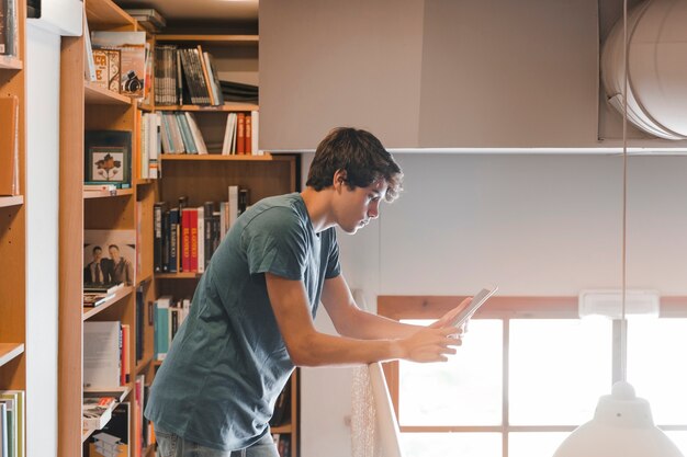 Adolescent, utilisation, tablette, près, balustrade, bibliothèque