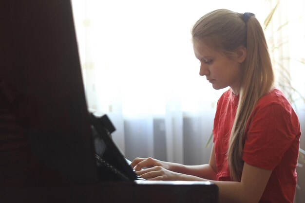 Adolescente Blonde De 14 Ans Jouant Du Piano à La Maison, Gros Plan Photo Premium