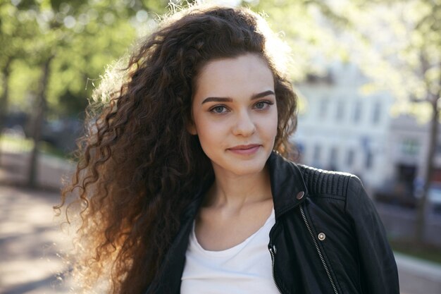 Une adolescente avec une coiffure ondulée posant