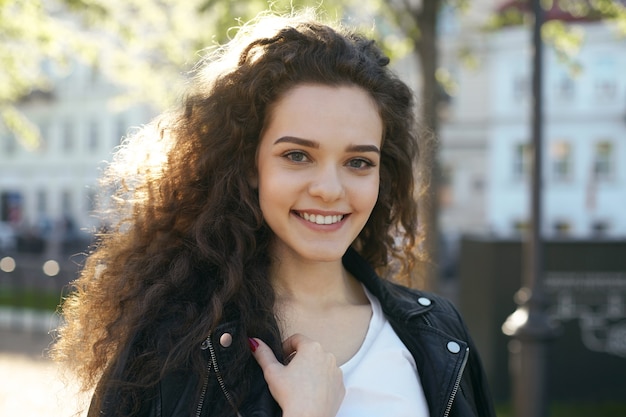 Une adolescente avec une coiffure ondulée posant