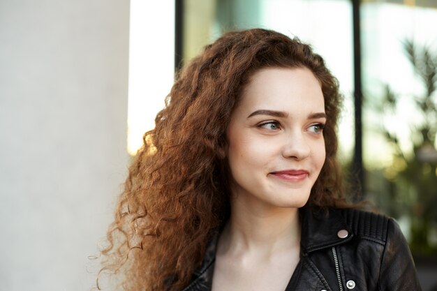 Une adolescente avec une coiffure ondulée posant