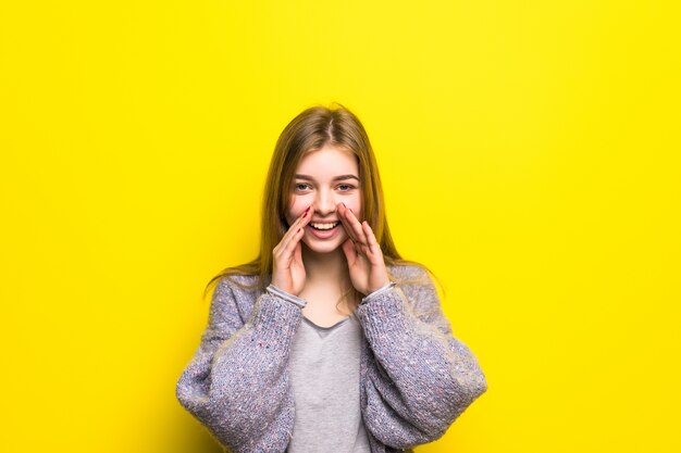 L'adolescente crie, ayant combiné les mains dans un mégaphone isolé