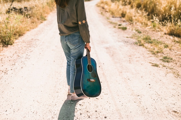 Adolescente, debout, route terre, tenue, guitare