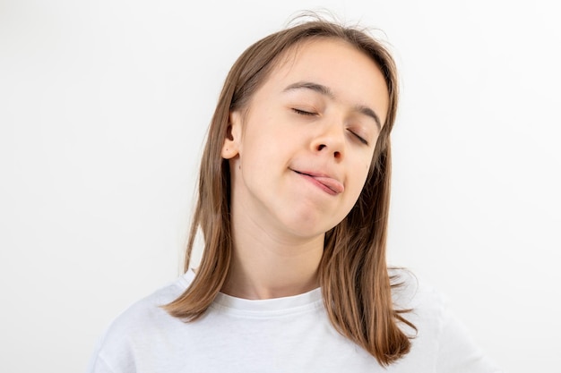 Photo gratuite une adolescente drôle lèche ses lèvres sur un fond blanc isolé