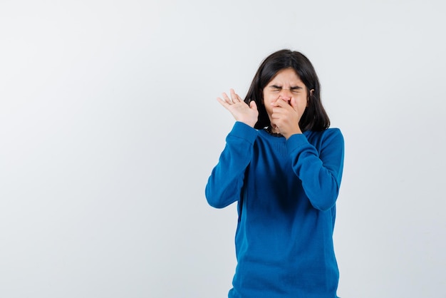 Adolescente éternue sur fond blanc