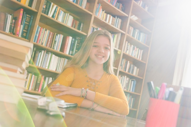 Photo gratuite adolescente intelligente animée, assis dans la bibliothèque