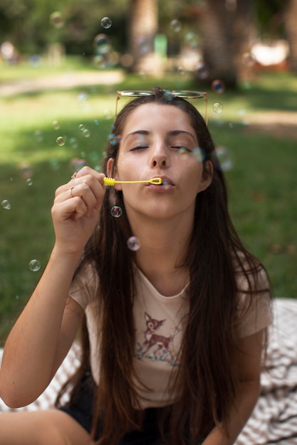 Adolescente jouant avec des bulles de savon