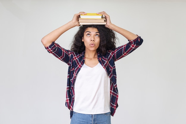 Photo gratuite adolescente ludique avec livre sur la tête