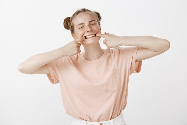 Adolescente mignonne ludique posant contre le mur blanc