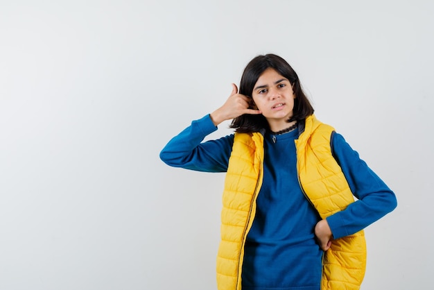 L'adolescente montre un geste de téléphone avec la main sur fond blanc