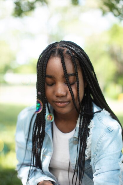 Adolescente noire mignonne jouant avec des bulles de savon