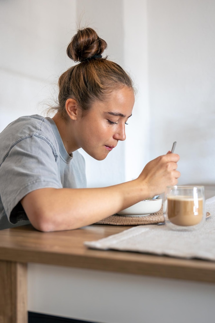 Photo gratuit une adolescente qui prend son petit déjeuner. un repas sain. un petit-déjeuner à la maison.