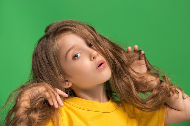 Photo gratuite adolescente réfléchie debout au studio vert