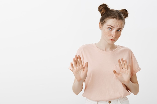 Photo gratuite adolescente réticente posant contre le mur blanc