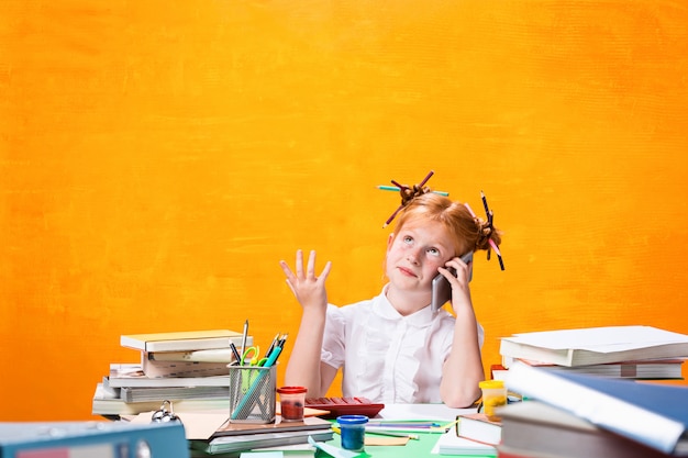 L'adolescente rousse avec beaucoup de livres à la maison. Prise de vue en studio