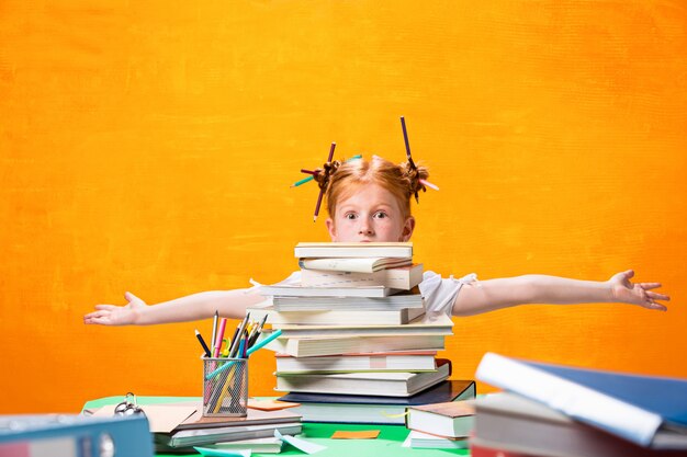 L'adolescente rousse avec beaucoup de livres à la maison.