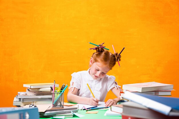 L'adolescente rousse avec beaucoup de livres à la maison.