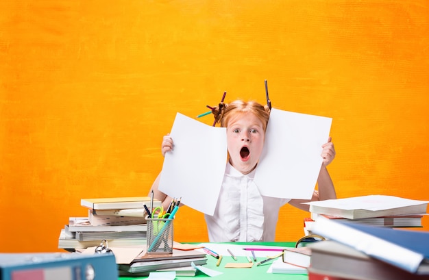 L'adolescente rousse avec beaucoup de livres à la maison.