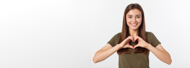 Adolescente souriante en forme de coeur avec ses mains isolées sur blanc