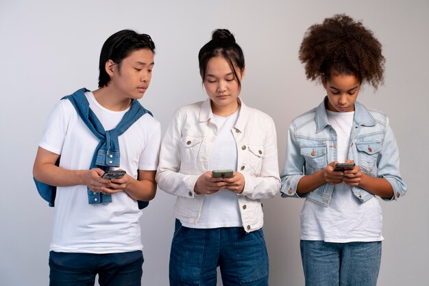 Adolescentes élégantes et garçon posant ensemble