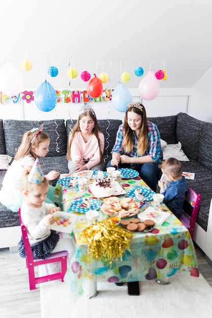 Adolescents et enfants mangeant le gâteau