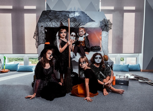 Photo gratuite des adolescents et des enfants sombres en costumes effrayants d'halloween posent pour le photographe.