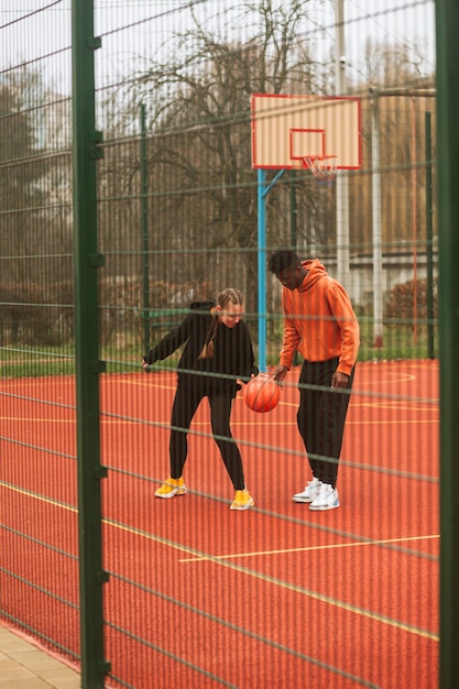 Adolescents jouant au basket en plein air