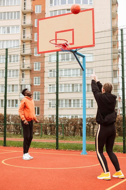 Adolescents jouant au basket en plein air
