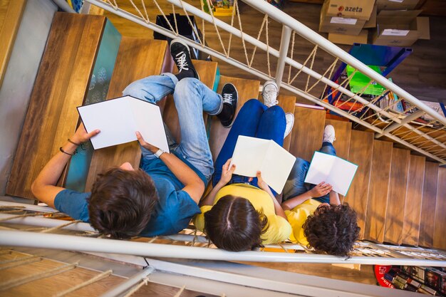 Adolescents méconnaissables, lisant dans l&#39;escalier