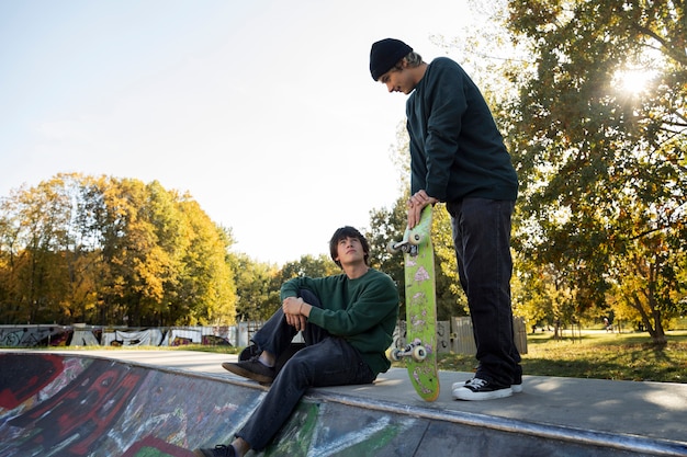 Adolescents rebelles en vue latérale du skatepark