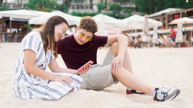 Photo gratuite adolescents se détendre ensemble à la plage