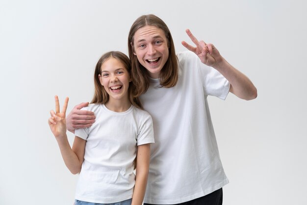 Adolescents souriants à coup moyen faisant le signe de la paix
