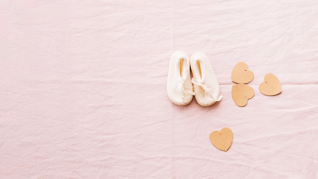Adorable bébé-chaussures et coeurs de papier