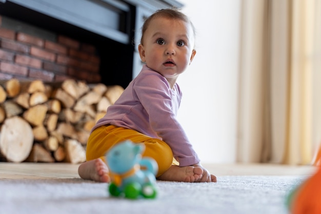 Adorable bébé jouant avec un jouet à la maison sur le sol