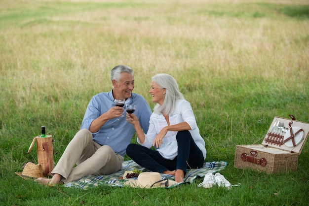 Adorable couple de personnes âgées ayant un pique-nique à l'extérieur