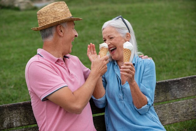 Adorable couple de personnes âgées dégustant une glace ensemble à l'extérieur