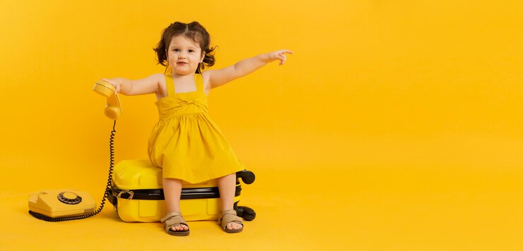 Photo gratuit adorable enfant posant avec téléphone et bagages