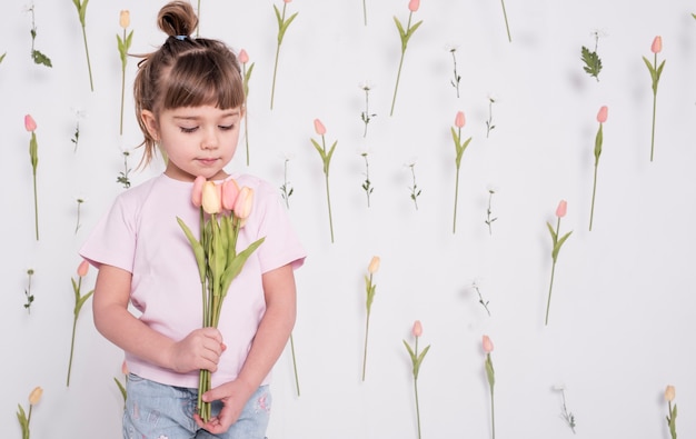 Adorable enfant regardant des tulipes